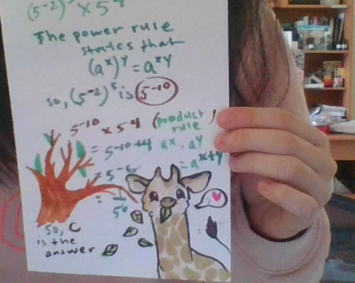 Hand-held illustrated student work with handwritten annotations.